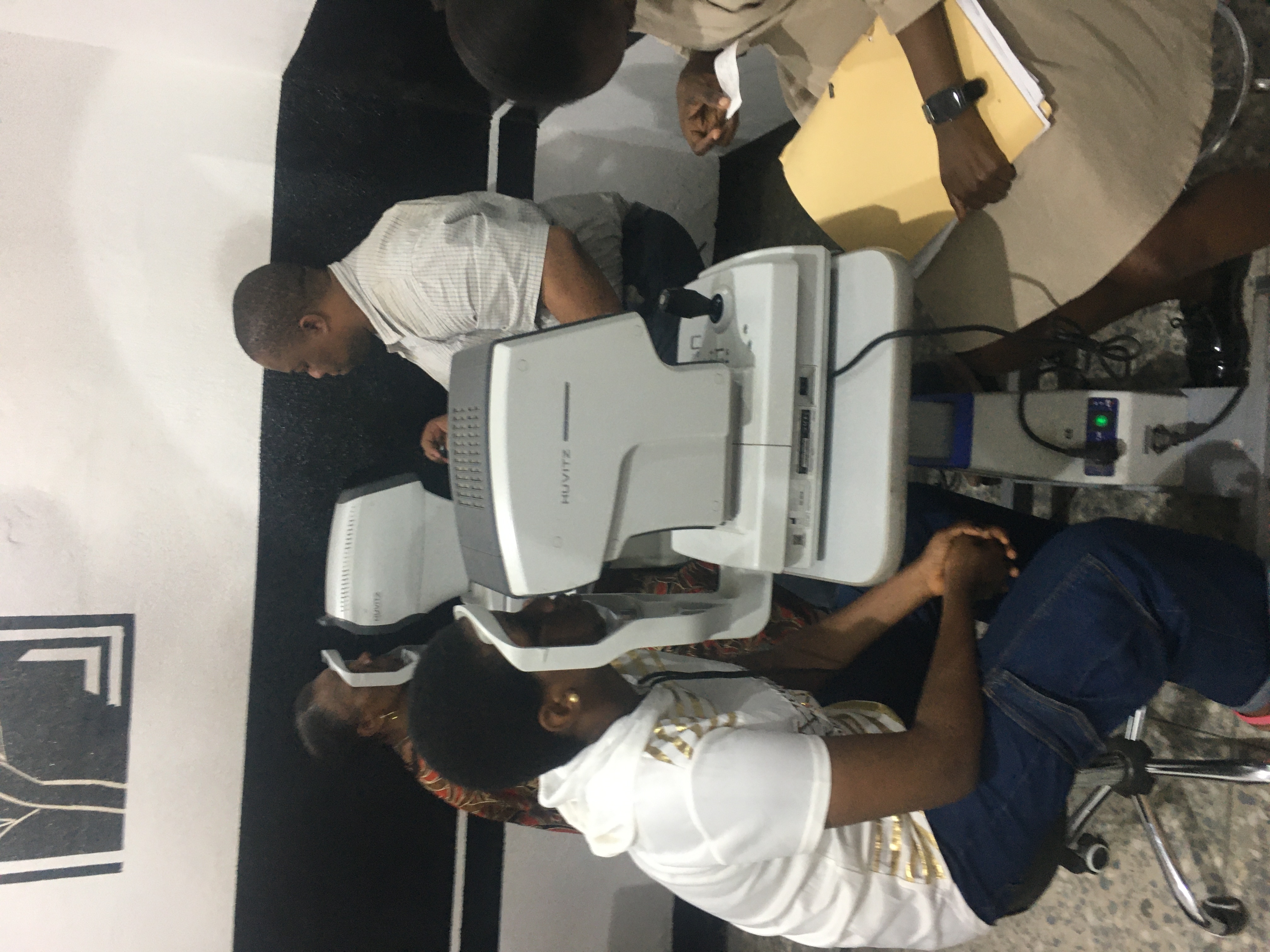 Patients seated inside an eye clinic waiting area.